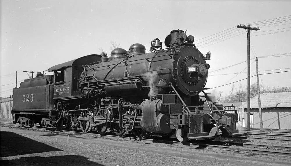 A black steam locomotive numbered 529, its tender lettered St. L.-S. W., standing on a track beside utility poles.